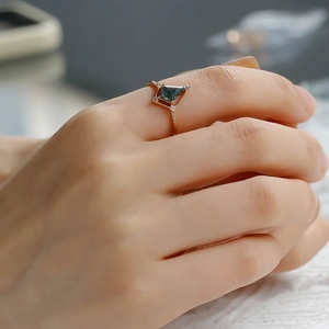 Vue macro d'une bague en agate mousse taille cerf-volant en or rose sur la main