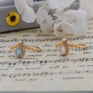 Detail of vintage 14k gold plated silver rings with pear-shaped blue and pink crystals