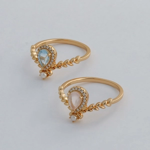 Macro detail of gold-plated silver rings featuring teardrop gemstones and leaf accents