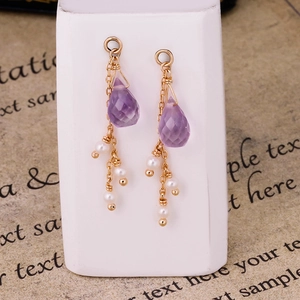 Dettaglio di pendenti in ametista viola con perle bianche e catene placcate in oro 14K
