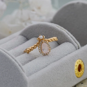 Macro view of gold leaf ring with teardrop pink quartz and pearl in a velvet box