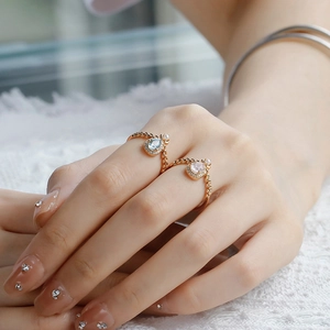 Detailed shot of pear-cut pink and blue crystal rings with 14k gold-plated textured bands