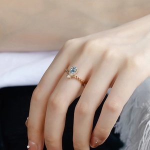 Detail of S925 silver 14k gold ring with pear-cut blue topaz and a small pearl