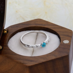 Close-up of S925 silver ring with blue apatite and star settings in a wooden box