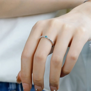 Detail of S925 silver rose thorn ring with blue apatite stone on model finger