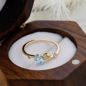 Macro detail of sky blue topaz and multi-gemstones in a 14K gold-plated silver ring