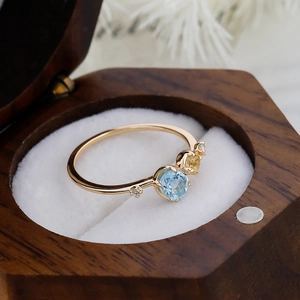 Macro shot of S925 silver 14K gold ring with sky blue topaz and yellow gemstones