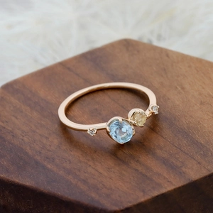 Macro shot of gold S925 ring featuring an oval sky blue topaz and round yellow gemstone