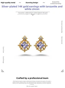 Detailed macro view of hollowed 14K gold plated silver earrings with purple tanzanite
