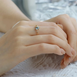 Detail view of S925 silver 14K gold ring with blue topaz and yellow sapphire on lace