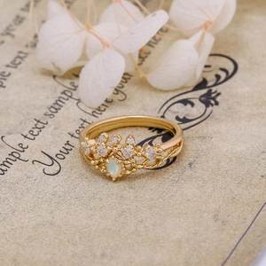 Macro detail of crown shaped S925 silver gold ring with opal and white zircon stones