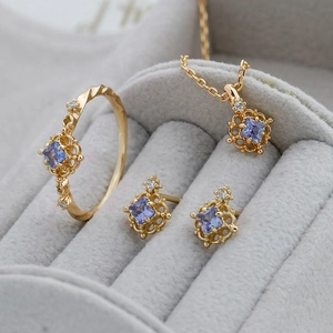 Detail view of gold S925 silver jewelry set with purple stones in a velvet display box