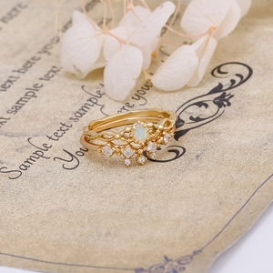 Detail of vintage gold-plated ring set with oval opal stone and crown zircon band