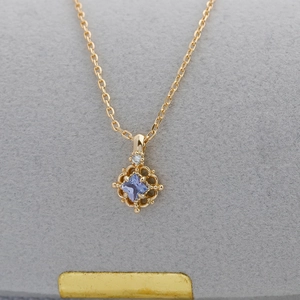 Macro shot of 14K gold-plated S925 silver necklace with square purple tanzanite pendant