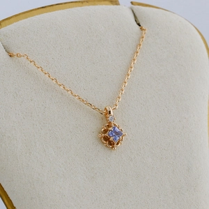Macro shot of 14K gold-plated S925 silver necklace with square violet tanzanite pendant