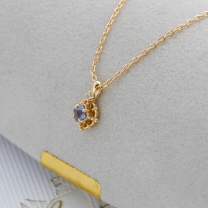Macro detail of S925 silver 14K gold plated pendant with oval tanzanite and zircon