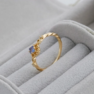 Detailed close-up of S925 silver 14K gold ring with square blue tanzanite and diamonds