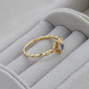 Macro shot of 14K gold-plated twisted ring with square-cut tanzanite gemstone