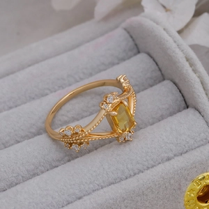 Detailed macro view of a 14k gold-plated crown ring with yellow rectangular gemstone
