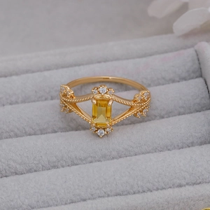 Macro shot of gold-plated silver ring featuring yellow crystal and ornate cutout details