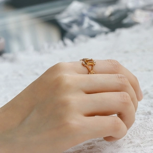 Detailed side view of 14k gold geometric ring featuring a yellow emerald-cut gemstone
