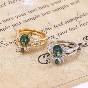 Macro shot of vintage style gold and silver moss agate rings with twisted band details