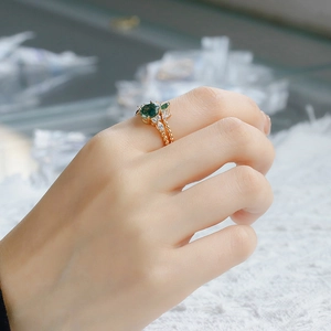 Detail of moss agate ring set with marquise stones on a rose gold beaded band