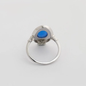 Französischer S925 Silberring mit ovalem blauem Opal auf grauem Hintergrund
