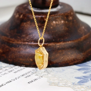 Macro-opname van de vintage schildhanger met gele edelsteen en bloemengravure