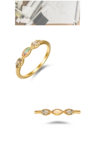 Detailed macro view of three-stone gold ring with opal and marquise-cut gems