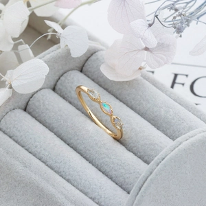 Detail of a vintage gold ring featuring a marquise opal and side zircon gemstones