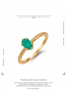 Detail of oval green chalcedony stone and engraved leaf patterns on silver gold ring