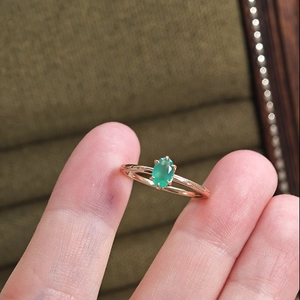 Close-up of oval green chalcedony ring in rose gold with vintage engraved texture