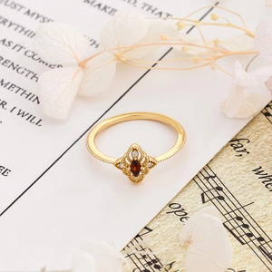 Detail eines Vintage-Rings mit marquise-geschliffenem roten Edelstein und Goldauflage