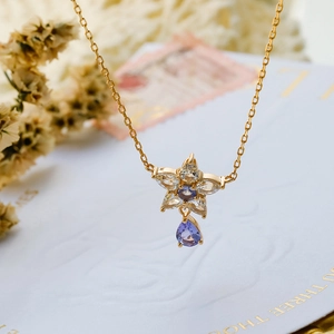 Dettaglio della collana a stella dorata con zircone tanzanite viola e pendente a goccia