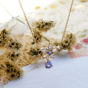 Dettaglio collana in argento s925 dorato con fiore e pietra zircone viola a goccia