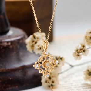 Detalle del colgante de plata dorada vintage con opalo natural y perlas en cadena fina