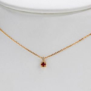 Élégant collier en argent avec pendentif rubis rouge rond présenté sur un mannequin