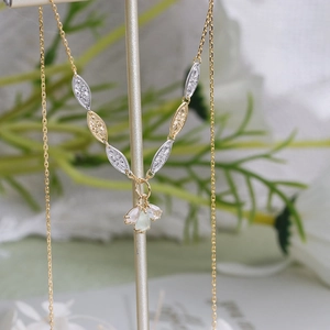 Detail of 14K gold plated silver necklace with water-drop crystals and engraved charms