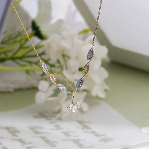 Macro shot of S925 silver 14K gold pendant with white crystal and petal metal texture
