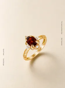 Dettaglio macro dell'anello in argento S925 placcato oro 14k con granato e zirconi bianchi