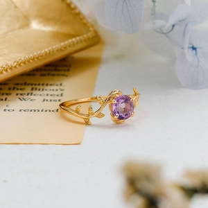 Detailed view of gold vine ring featuring a round purple amethyst and intricate leaf texture