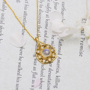 Macro detail of S925 gold-plated necklace with moonstone and white zircon pendant