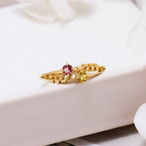 Detail of S925 gold plated ring with red and yellow gemstones in leaf design