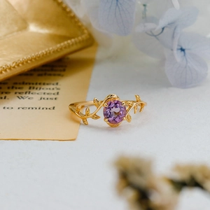Macro shot of nature inspired gold leaf ring with oval purple amethyst gemstone