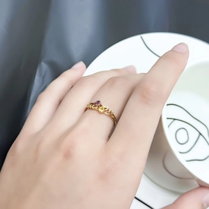 Detail showing an elegant S925 silver gold-plated ring with leaf vine patterns and gemstones