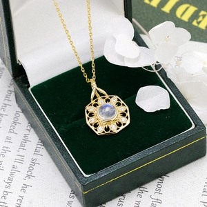 Detail of s925 gold-plated necklace with moonstone pendant in green velvet gift box