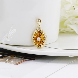Détail du pendentif vintage en argent doré avec ambre ovale et petite gemme d'opale
