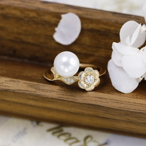 Close-up of luxury lotus pearl ring with moissanite accents and golden floral detail