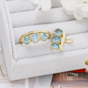 Detail shot of vintage s925 gold-plated rings and pendants with three blue oval gemstones
